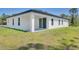 Rear exterior showcasing a modern home with a covered patio and landscaped lawn at 2290 Beeville Ave, North Port, FL 34286