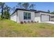 Stylish single Gathering home showcasing a modern stucco facade, gray window trim, green lawn, and minimal landscaping at 2290 Beeville Ave, North Port, FL 34286