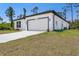 Beautiful single Gathering home featuring a two-car garage, and a modern stucco facade with dark trim and manicured lawn at 2290 Beeville Ave, North Port, FL 34286