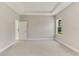 Neutral bedroom offers tray ceilings, carpeted floors, and an open doorway to bathroom at 2290 Beeville Ave, North Port, FL 34286