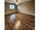 A secondary bedroom featuring a ceiling fan and neutral wall paint over sleek dark wood floors at 2300 Stickney Point Rd # 125, Sarasota, FL 34231