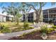 Beautifully landscaped common area with a brick walkway leading to a patio seating area at 2300 Stickney Point Rd # 125, Sarasota, FL 34231