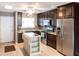 Modern kitchen with stainless steel appliances, custom cabinets, tile backsplash, and a movable island at 2300 Stickney Point Rd # 125, Sarasota, FL 34231