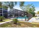 Enclosed community pool surrounded by lounge chairs and tropical greenery at 2300 Stickney Point Rd # 125, Sarasota, FL 34231