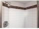 Tiled shower with mosaic tile accent stripe and a chrome shower head at 2300 Stickney Point Rd # 125, Sarasota, FL 34231