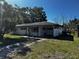 Street view of a single story home with white painted siding and mature trees at 2503 23Rd W Ave, Bradenton, FL 34205