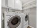 Well-equipped laundry room with washer, dryer, storage cabinets, and shelving at 2536 Carlisle Pl, Sarasota, FL 34231