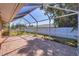 Wide view of the brick-paved, screened-in patio and backyard at 2536 Carlisle Pl, Sarasota, FL 34231