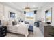 Beautiful primary bedroom features a tray ceiling, large window, and elegant furnishings with blue accents at 256 Van Gogh Cv, Bradenton, FL 34212