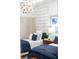 Charming bedroom featuring twin beds with stylish navy and white bedding, complemented by a modern chandelier at 256 Van Gogh Cv, Bradenton, FL 34212