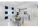 Bright dining room featuring modern light fixture, elegant table setting and direct access to the kitchen at 256 Van Gogh Cv, Bradenton, FL 34212
