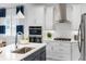 Modern kitchen with stainless steel appliances, white cabinetry, and a stylish range hood at 256 Van Gogh Cv, Bradenton, FL 34212