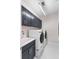 Modern laundry room boasts gray cabinets, white tile flooring, and front-loading washer and dryer units at 256 Van Gogh Cv, Bradenton, FL 34212