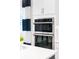 Modern white kitchen features stainless steel double wall ovens adding functionality and style to the space at 256 Van Gogh Cv, Bradenton, FL 34212