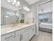 Bathroom with double vanity, glass enclosed shower, and view to the Primary bedroom at 27061 Paradise Shores Dr, Englewood, FL 34223