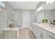 Modern bathroom with double vanity, glass enclosed shower, and neutral color palette at 27061 Paradise Shores Dr, Englewood, FL 34223
