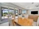 Dining area with a wooden table and chairs, adjacent to a screened patio area at 27061 Paradise Shores Dr, Englewood, FL 34223