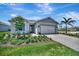 Beautiful single-story home with a brick driveway and lush landscaping at 27061 Paradise Shores Dr, Englewood, FL 34223