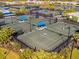 Aerial view of the community tennis courts featuring shaded seating between the courts at 27061 Paradise Shores Dr, Englewood, FL 34223