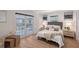 Cozy bedroom with wood floors, neutral decor, and french doors leading to a private balcony at 2833 Bay Shore Cir, Sarasota, FL 34234
