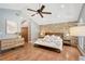 Primary bedroom with a decorative brick wall, wood floors, ceiling fan, and accent lighting at 2833 Bay Shore Cir, Sarasota, FL 34234