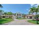 Stunning two-story home with a clay tile roof and circular driveway, surrounded by lush landscaping at 2833 Bay Shore Cir, Sarasota, FL 34234