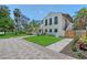 Exterior of white home featuring a lush front lawn, mature trees and a brick driveway at 2833 Bay Shore Cir, Sarasota, FL 34234
