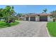 Exterior shot of home showcasing a paved driveway leading up to a three-car garage at 2833 Bay Shore Cir, Sarasota, FL 34234