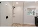 Shower with pebble floor, subway tile, frameless glass door and dark fixtures at 2833 Bay Shore Cir, Sarasota, FL 34234