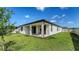 A backyard with a covered patio, sliding glass doors, and a well-maintained lawn at 2907 61St E Ter, Ellenton, FL 34222
