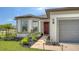 Inviting home exterior featuring a red front door, manicured landscaping, and walkway lights at 2907 61St E Ter, Ellenton, FL 34222