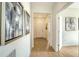Inviting hallway with light wood floors and stylish artwork leads to the front door and other rooms at 2907 61St E Ter, Ellenton, FL 34222