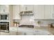 Close-up of a modern kitchen showcasing a stainless steel hood, gas range, and white subway tile backsplash at 2907 61St E Ter, Ellenton, FL 34222
