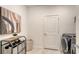 Well-organized laundry room with a washer, storage unit, and a stylish piece of artwork at 2907 61St E Ter, Ellenton, FL 34222