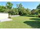 Large, grassy backyard enclosed by white fencing and mature trees offering seclusion at 3647 Country Place Blvd, Sarasota, FL 34233