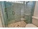Tiled walk-in shower with glass, decorative tile floor, shower niche, and glass block accent at 3647 Country Place Blvd, Sarasota, FL 34233