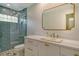 Stylish bathroom with glass shower, white vanity, gold hardware, and a decorative mirror at 3647 Country Place Blvd, Sarasota, FL 34233