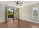 Spacious bedroom features a ceiling fan, a large window with shutters and a large sliding door to the outside at 3647 Country Place Blvd, Sarasota, FL 34233
