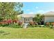 Charming home features a beautifully landscaped front yard, complete with lush green grass and colorful flowerbeds at 3647 Country Place Blvd, Sarasota, FL 34233