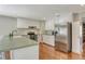 Bright kitchen featuring white cabinets, stainless steel appliances, and a breakfast bar area at 3647 Country Place Blvd, Sarasota, FL 34233