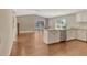 Bright kitchen featuring white cabinets, an island with seating, stainless steel appliances, and wood-look flooring at 3647 Country Place Blvd, Sarasota, FL 34233