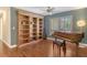 Spacious living room with hardwood floors, built-in shelving, and piano at 3647 Country Place Blvd, Sarasota, FL 34233