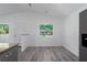 Open-concept dining area featuring gray wood flooring, white walls, and backyard views at 3712 19Th E St, Bradenton, FL 34208