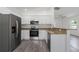 Modern kitchen featuring stainless steel appliances, granite countertops, and gray wood flooring at 3712 19Th E St, Bradenton, FL 34208