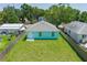 Aerial shot showcasing the light teal home with a spacious backyard and light gray roof at 3712 19Th E St, Bradenton, FL 34208