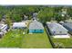 Aerial view of a cozy light teal house featuring a well-maintained lawn and light gray roof at 3712 19Th E St, Bradenton, FL 34208