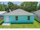 Close up of light teal home's rear exterior, highlighting the back door entrance and surrounding green grass at 3712 19Th E St, Bradenton, FL 34208