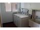 Laundry room featuring a washer, dryer, sink, and shelving providing a convenient space for laundry needs at 3751 S School Ave # 19, Sarasota, FL 34239
