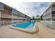 Community pool surrounded by a white fence, with clear blue water, lounge chairs, and well maintained landscaping at 3751 S School Ave # 19, Sarasota, FL 34239