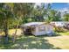 Charming single-story home featuring a screened porch and a lush green lawn with mature trees at 409 Olive Ave, Nokomis, FL 34275